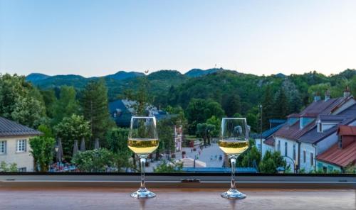 two glasses of white wine sitting on a table at 086 Studio Apartment in Cetinje