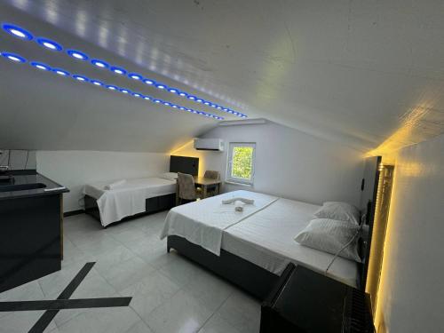 a bedroom with two beds and a tv and lights at Gökçe Apart & Pansiyon Amasra in Amasra