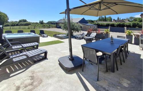 a blue table and chairs under an umbrella at Beautiful Home In Pordic With Wifi in Pordic
