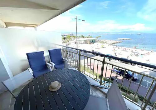 a balcony with a table and chairs and a beach at Cap d'Antibes Studio et terrasse face à la mer in Antibes