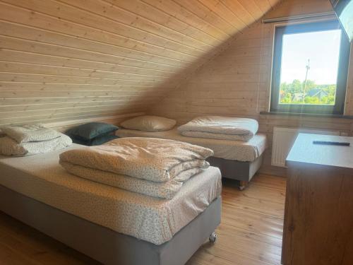 a room with three beds in a wooden cabin at Domki Nad Stawem Mazury D3 in Mrągowo