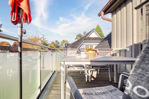 un patio con tavolo e sedie su un balcone di FEWO MW8 Zingst - 5min zum Strand - Ostseefeeling & hochwertige Küchenausstattung a Zingst