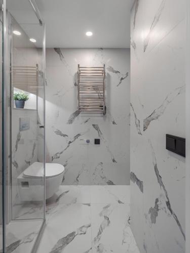a bathroom with a toilet and a glass shower at Brand New Loft 61 in Pakopi