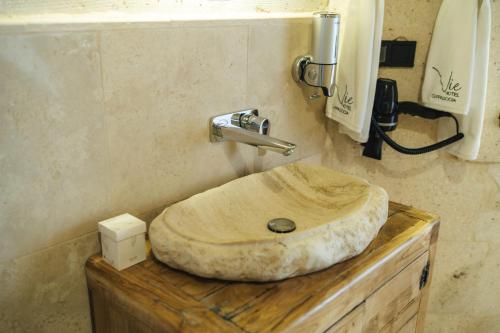 a bathroom sink with a wooden bowl on a counter at Vie Cappadocia - Adults Only in Nevsehir