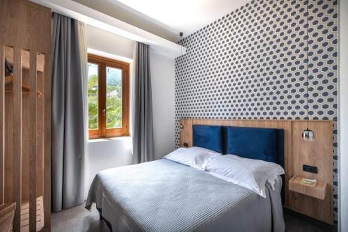 a bedroom with a bed with a blue headboard at Villa Margherita in Cefalù
