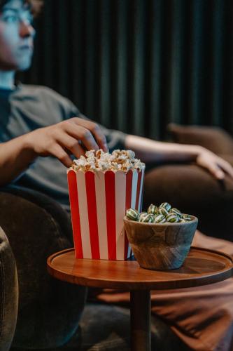 a man sitting on a couch with a box of popcorn at Mason & Fifth, Westbourne Park in London