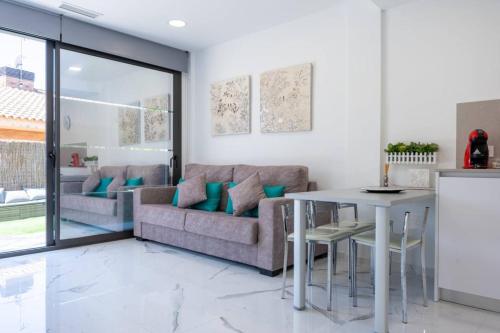 a living room with a couch and a table at Apartamentos Rosa de Abril in Teià