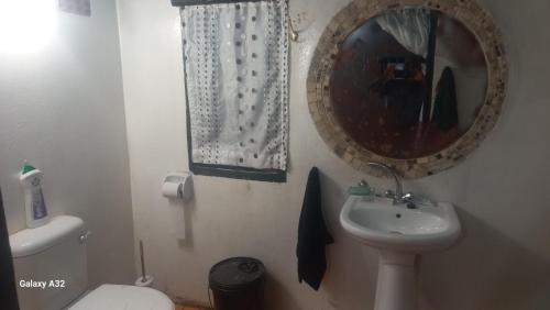 a bathroom with a sink and a mirror and a toilet at BUFFALO INN onsuite in KwaNompondo
