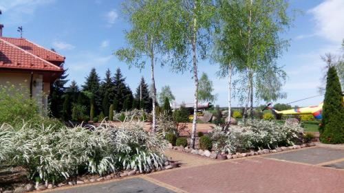 a garden with palm trees and a playground at Skrzydlate Ranczo in Włodawa