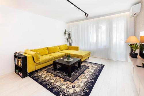 a living room with a yellow couch and a table at D-home in Sofia