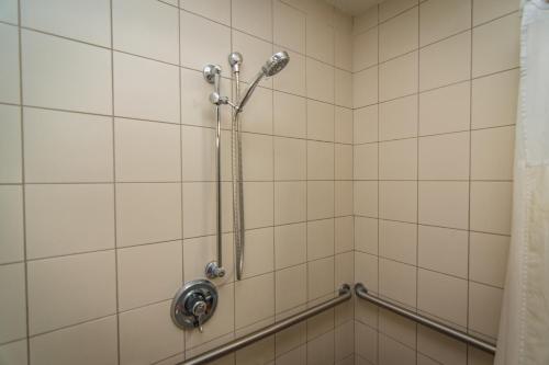 a shower in a bathroom with white tiles at Motel 6-Lakeland, FL in Lakeland