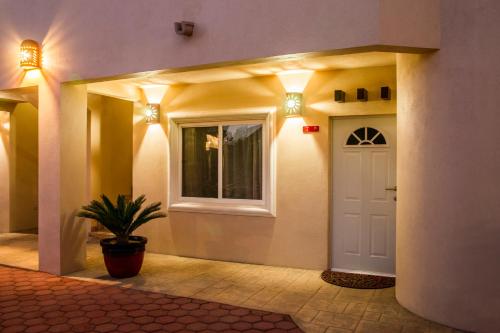 a hallway with a white door and a potted plant at Bugambilias Suites in Loreto