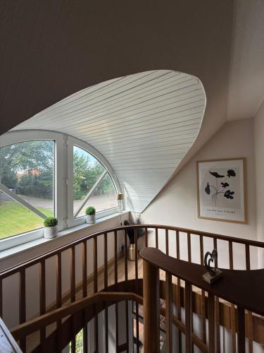 a room with a spiral staircase with a large window at Waldhotel Süllhof in Steyerberg