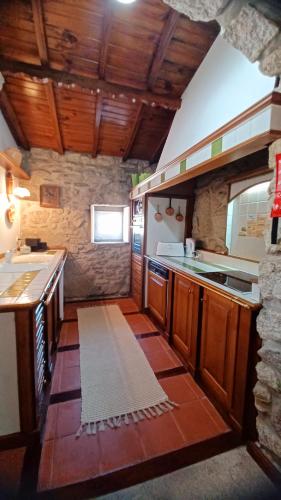 a kitchen with wooden cabinets and a counter top at Quintinha dos Amores in Vila Verde