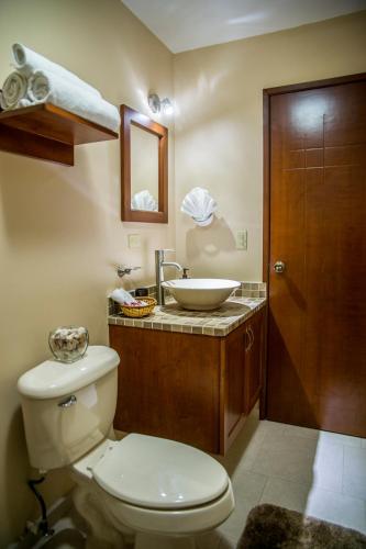 a bathroom with a toilet and a sink at Bugambilias Suites in Loreto