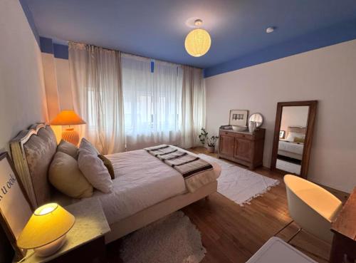 a bedroom with a large bed and a mirror at Gezellig nestje in lichtrijk huis met wilde tuin in Brussels