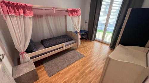 a bedroom with a bed with curtains and a window at Villa Melanie in Überlingen