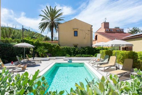 a swimming pool with lounge chairs and a house at Villa Margherita in Cefalù