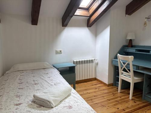 a bedroom with a bed and a desk and a chair at BPirineos-La Montañeta in Benasque