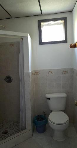 a bathroom with a toilet and a window at La Casa de Don David in El Remate
