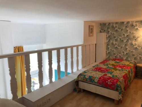 a small bedroom with a bed and a staircase at Plage de Saint Clair à 50m in Le Lavandou