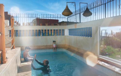 a couple of kids playing in a swimming pool at BLUE WAVE LODGE in Imi Ouaddar
