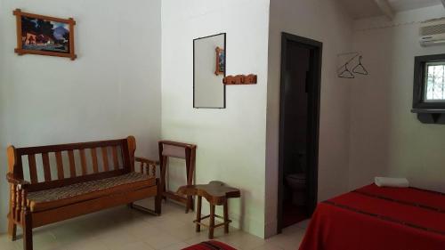 a room with a bench and a bed and a window at La Casa de Don David in El Remate