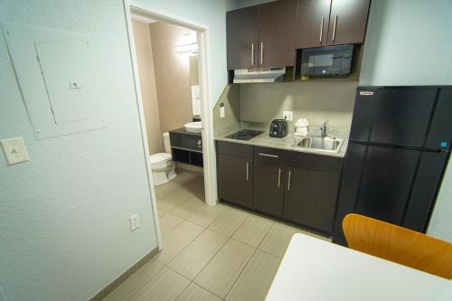 Una cocina con un refrigerador negro y un fregadero. en Studio 6-Coral Springs, FL - Fort Lauderdale, en Coral Springs