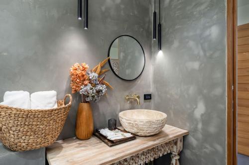 a bathroom with a sink and a mirror at Villa Seawadee - luxurious, award-winning design Villa with amazing panoramic seaview in Chaweng Noi Beach