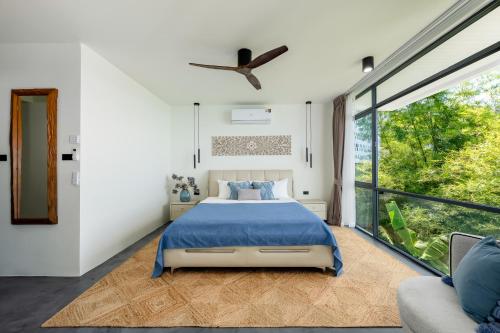 a bedroom with a bed and a large window at Villa Seawadee - luxurious, award-winning design Villa with amazing panoramic seaview in Chaweng Noi Beach