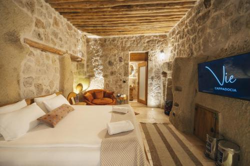 a bedroom with a white bed in a stone wall at Vie Cappadocia - Adults Only in Nevsehir