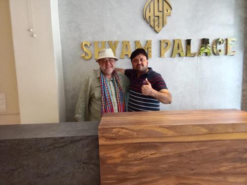 two men are standing in front of a counter at HOTEL SHYAM PALACE INDIA AGRA in Agra