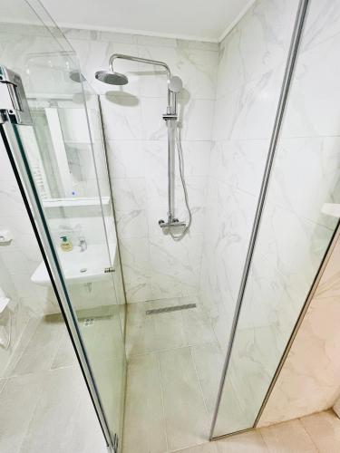 a shower with a glass door in a bathroom at AMARIS Suites Sarajevo in Sarajevo
