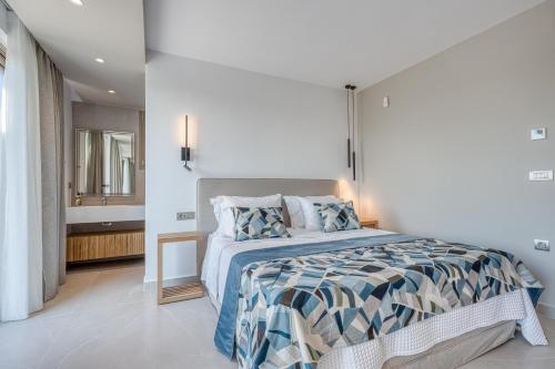 a white bedroom with a bed and a bathroom at Villa Stafida Kassiopi in Kassiopi