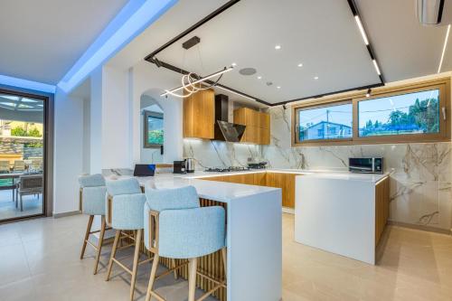 a kitchen with a white counter and stools at Villa Stafida Kassiopi in Kassiopi
