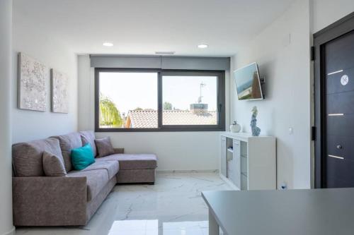 a living room with a couch and a table at Apartamentos Rosa de Abril in Teià