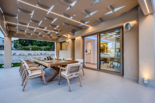 a dining room with a table and chairs on a patio at Villa Stafida Kassiopi in Kassiopi