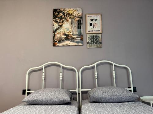 a bedroom with two beds and a painting on the wall at Bentley Floriana Suites in Il-Furjana