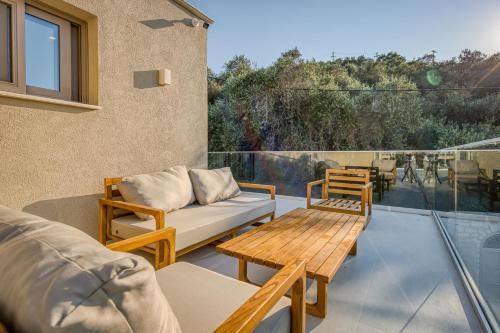 a patio with a couch and chairs on a balcony at Villa Stafida Kassiopi in Kassiopi