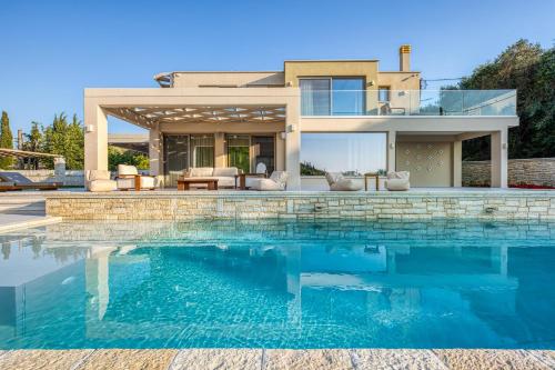 a swimming pool in front of a house at Villa Stafida Kassiopi in Kassiopi