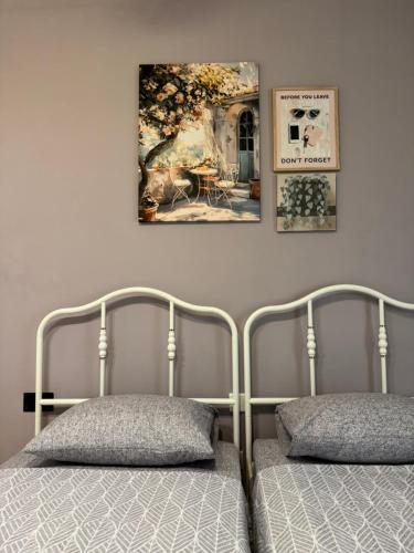 a bedroom with two beds and a painting on the wall at Bentley Floriana Suites in Il-Furjana