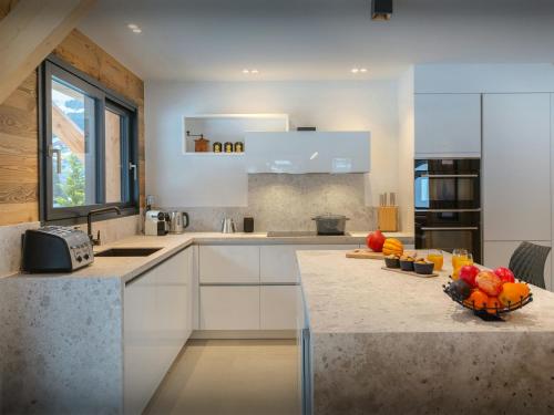 a kitchen with a counter with a bowl of fruit on it at Chalet Alphonse - OVO Network in Châtel