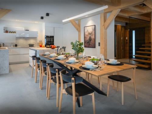 a dining room with a long wooden table and chairs at Chalet Alphonse - OVO Network in Châtel