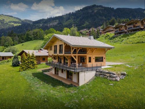 a large wooden house in a field of grass at Chalet Alphonse - OVO Network in Châtel
