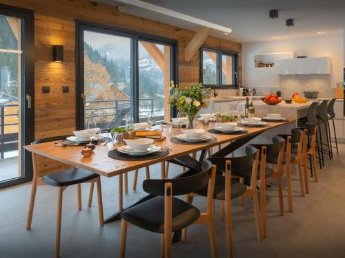 a large dining room with a long table and chairs at Chalet Alphonse - OVO Network in Châtel
