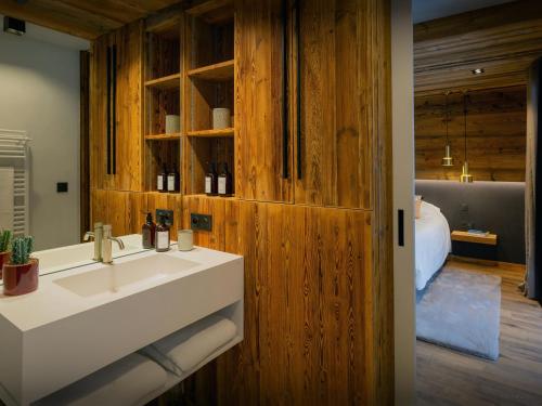 a bathroom with a sink and a bed in a room at Chalet Alphonse - OVO Network in Châtel