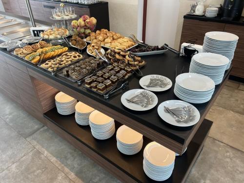 a buffet with plates and food on a table at Canada Hotel Budapest in Budapest