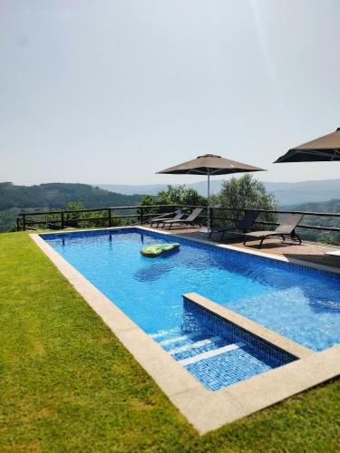 a swimming pool with a boat in the grass at A Casa da Japoneira CB in Rebordões