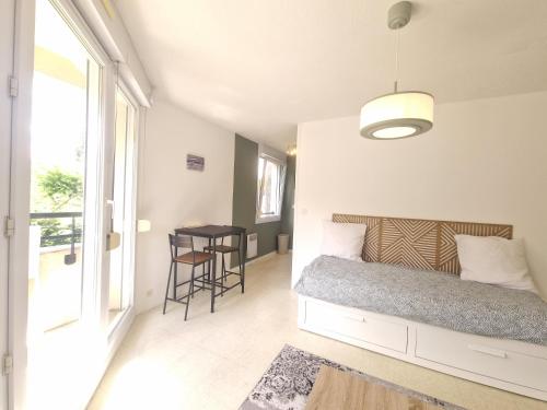 une chambre avec un lit et une table avec des chaises dans l'établissement Le Lautrec #Parking, à Chamalières