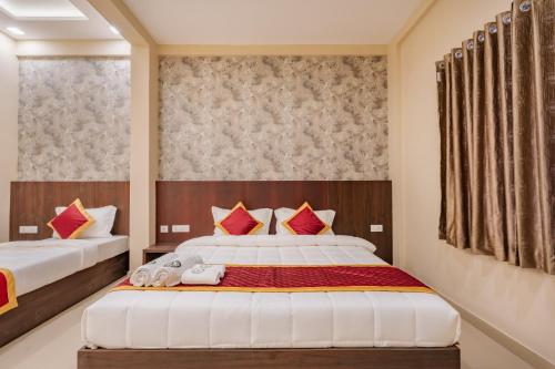 a bedroom with two beds with red and white pillows at Boat Residency in Cochin
